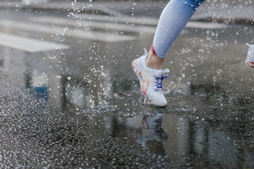 Foto von cottonbro von Pexels: Frau läuft bei Regen Ausschnitt Bein